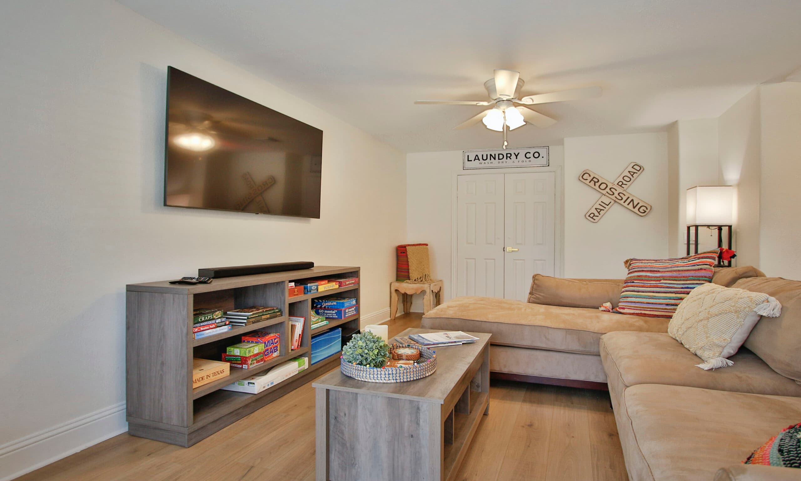 Den with smart TV, board games, and railroad crossing decor