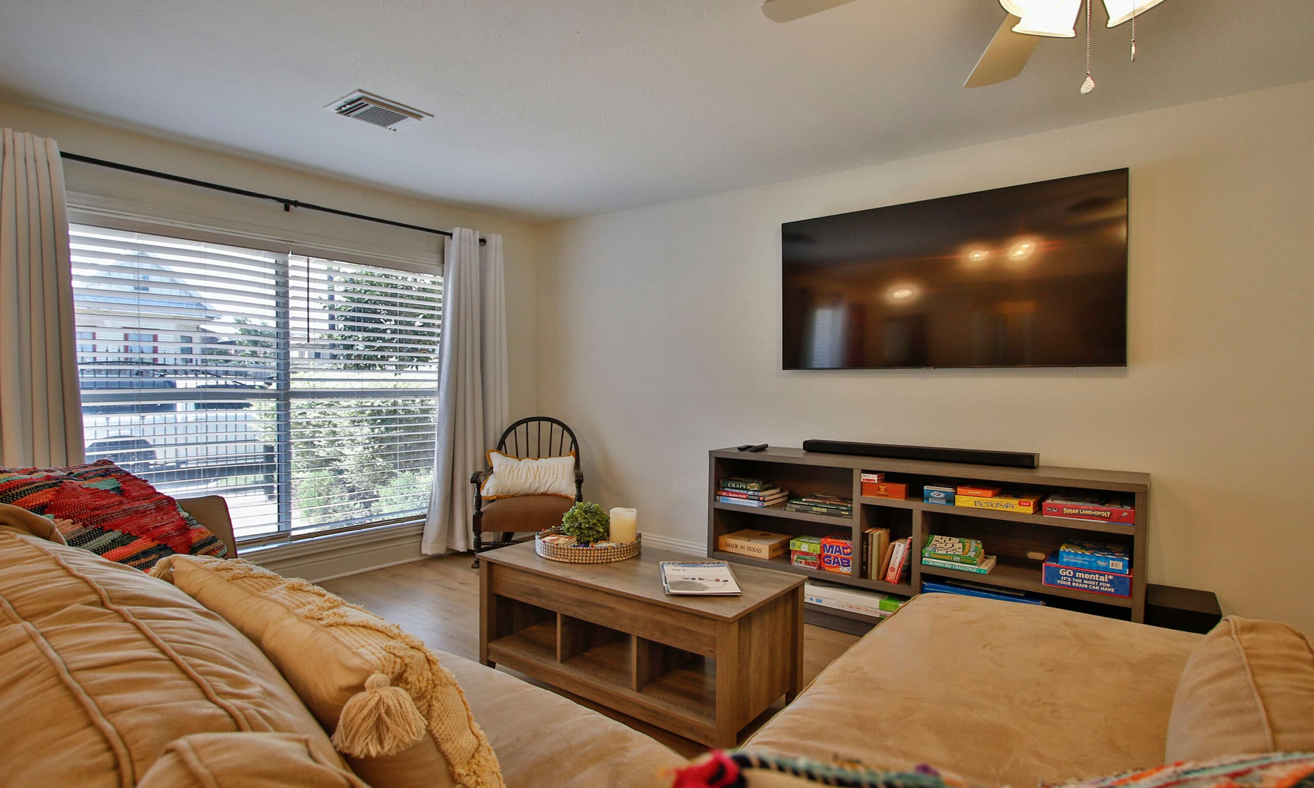 Den with large window, sectional sofa, and entertainment area